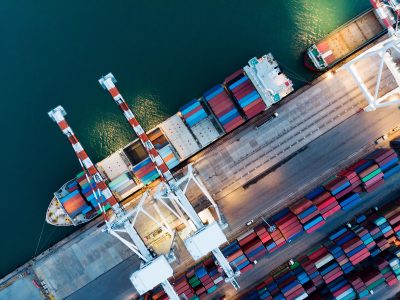 Cargo container ship at the cargo international container depot yard port and crane loading tank for export freight shipping by ship , logistic smart service and transportation.